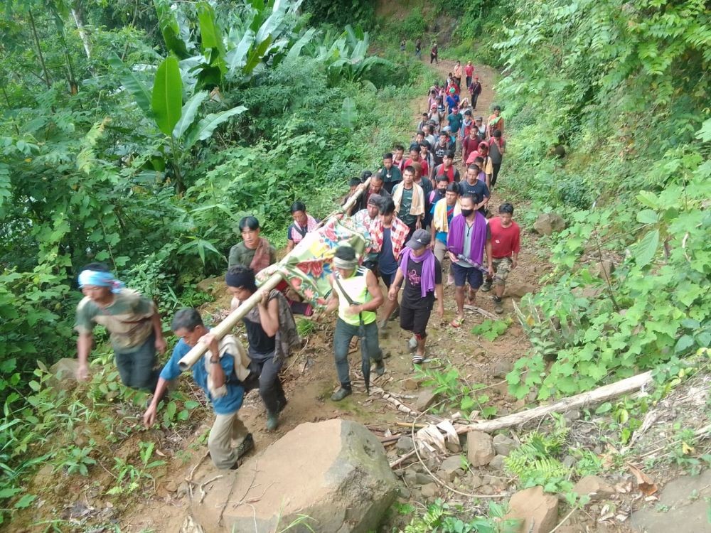 Villagers of Lalong, Peren district, transporting an ailing nonagenarian to hospital on foot on July 22.